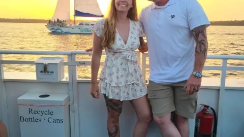 a man and a woman standing in front of a boat
