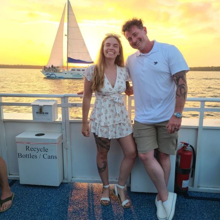a man and a woman standing in front of a boat