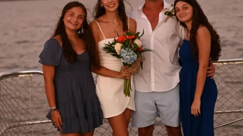 a group of people on a beach posing for the camera
